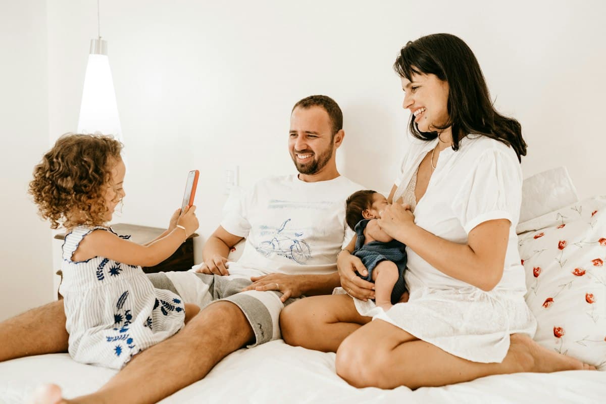 Parents and toddler on a white bed