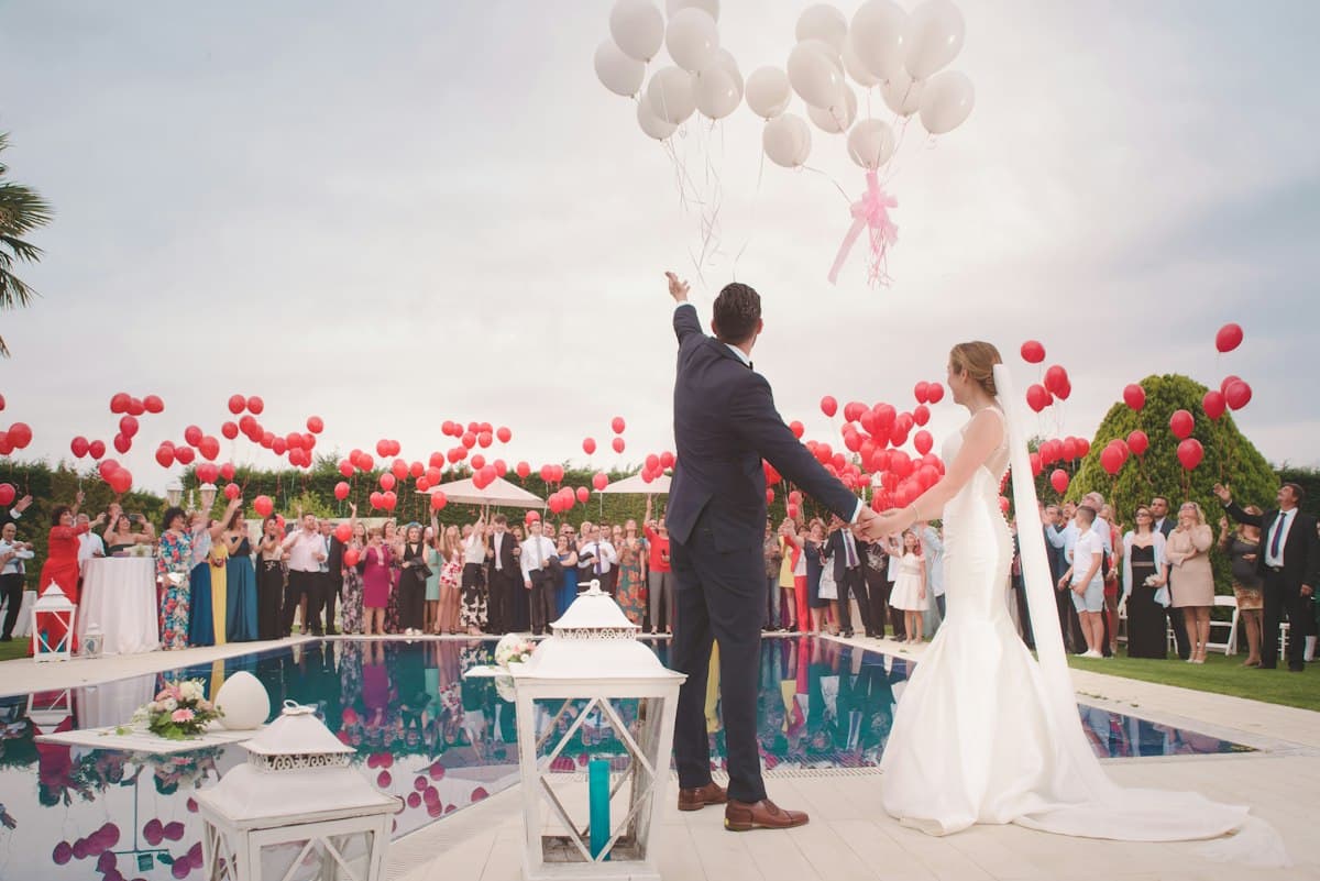 Groom releasing balloons over a crowd